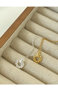 Detailed close-up of gold and silver twisted Mobius rings on a premium jewelry box