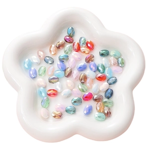 Flat oval faceted transparent crystal glass beads for DIY jewelry making in a floral dish
