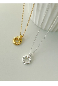 Macro detail of twisted texture on Mobius rings in gold and silver finish necklaces