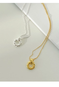 Detail view of twisted Mobius loop pendants in gold and silver finish with fine chains