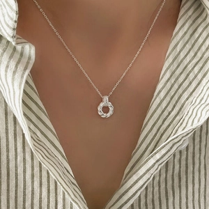 925 sterling silver Mobius twist circle necklace on a model in a striped shirt