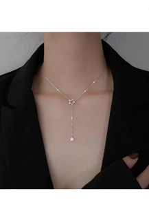 Détail du collier à pampilles étoiles en argent S925 porté sur un blazer noir