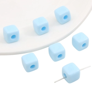 Macro view of light blue acrylic cube beads with smooth finish for DIY jewelry crafts