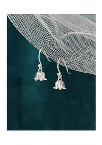 Macro de boucles d'oreilles muguet en argent sterling S925 sur un filet blanc doux