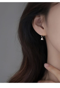 Gros plan de boucles d'oreilles muguet en argent S925 portées par un mannequin femme