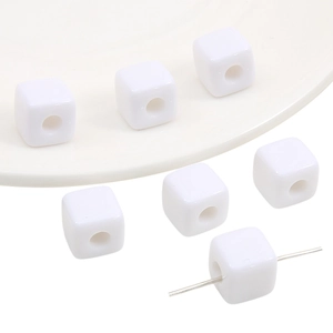 Macro shot of white acrylic square beads with straight holes for DIY jewelry making