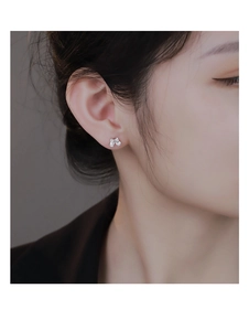 Gros plan de boucles d'oreilles nœud en argent S925 avec zircons sur le lobe