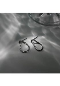 Détail des boucles d'oreilles goutte en argent S925 avec une texture scintillante