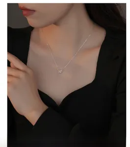 Détail d'un collier pendentif papillon en argent S925 sur un mannequin portant du noir