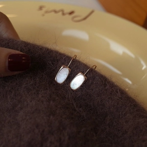 Detail of S925 silver shell earrings with oval mother of pearl in a vintage gold finish