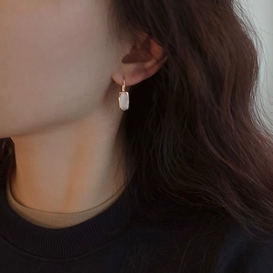 Close-up of S925 silver shell earrings with gold frame on model for elegant French look