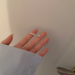 Elegante bracciale in argento S925 con stella a otto punte e perla al polso di una donna