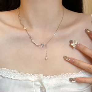 Dettaglio della collana in argento S925 con pendente a stella e catena di perle sul collo