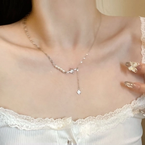 Dettaglio del ciondolo a stella in argento S925 e perle indossato sul collo di modella