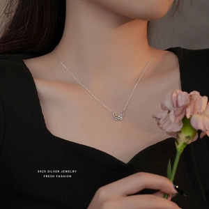 Détail macro du collier papillon en argent S925 avec gemmes roses sur mannequin