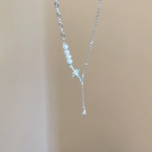 Vista dettagliata della collana in argento S925 con perle finte e un ciondolo a stella a otto punte