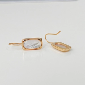 Detail view of S925 silver gold-plated rectangular shell drop earrings with white pearl luster