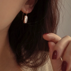 Close-up of S925 silver French shell drop earrings with rose gold plating on a model