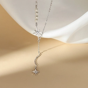 Dettaglio della collana in argento S925 con perle bianche e ciondoli a stella su seta