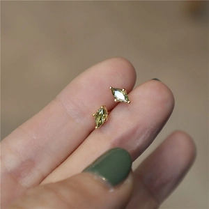 Detailed macro view of olive green marquise cut silver studs in gold four-claw setting