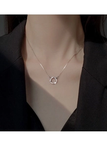 Détail du collier Mobius en argent S999 avec zircons porté sur un tailleur noir
