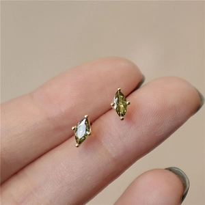 Macro shot of marquise-cut olive green stud earrings showing delicate gold claw setting