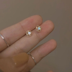Close-up of S925 silver four-leaf flower studs with gold frame and white opal stone