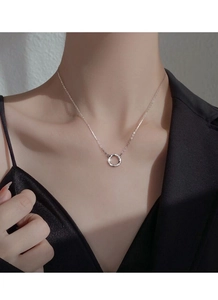 Gros plan du collier Mobius en argent S999 minimaliste porté par une femme en col en V