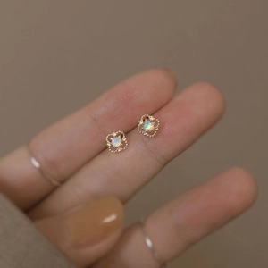 Detail of S925 silver French hollow flower earring with iridescent opal center stone