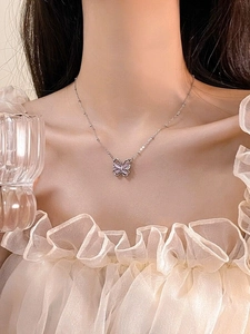 Nahaufnahme der S925 Silberkette mit rosa Schmetterlingsanhänger am Hals eines Modells