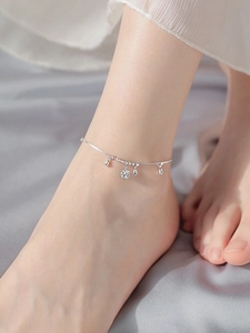 Detailed shot of S925 sterling silver anklet with delicate bells and hollow sphere charm