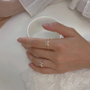 Close-up of S925 silver bow rings with zircon stones in gold and silver finishes