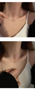 Detailed close-up of a S925 sterling silver necklace with elegant white pearls on a model