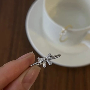 Detailed macro of S925 silver bow ring with shimmering cubic zirconia on hand