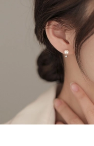 Close-up of minimalist S925 silver stud earring with white freshwater pearl on model