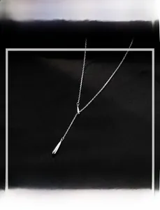 Détail d'un collier goutte en argent S925 avec curseur réglable sur de la soie noire