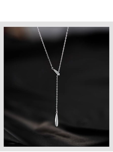 Gros plan du collier en Y argenté avec pendentifs en forme de goutte polis