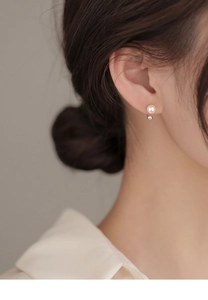 Detail shot of a minimalist S925 silver stud earring with a glossy white freshwater pearl