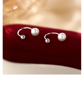 Detailed view of S925 sterling silver U-shaped pearl earrings on red velvet box