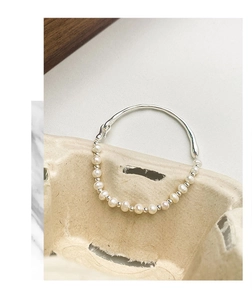 Détail d'un bracelet en argent s925 avec perles d'eau douce et tige métallique minimaliste