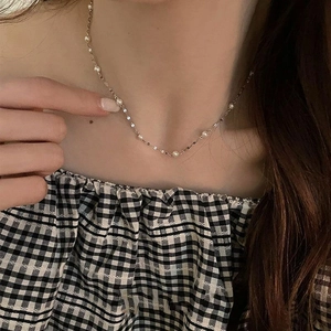 Elegant S925 sterling silver necklace with delicate white pearls worn by a model
