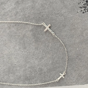 Detailed close-up of S925 sterling silver chain with minimalist double cross pendants
