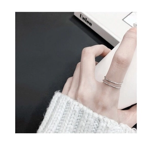 Gros plan d'une bague double couche minimaliste en argent S925 portée au doigt