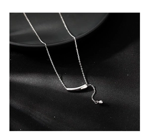 Vue macro du pendentif courbe en argent S925 avec petite perle sur tissu en soie noire