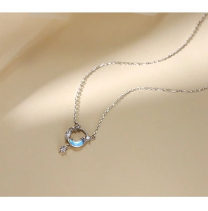Detalle macro del colgante de luna y estrella en plata S925 con piedras azules y circonitas