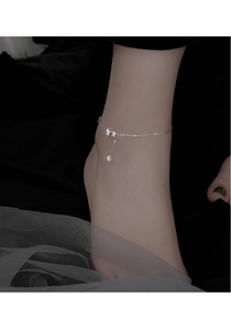 Détail de la chevillère papillon en argent avec zircon sur la cheville d'un mannequin