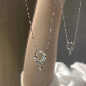 Detalle macro del colgante de luna y estrella en plata S925 con cristal azul claro