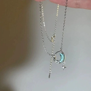 Detalle del colgante de luna en plata S925 con gema azul y una pequeña estrella