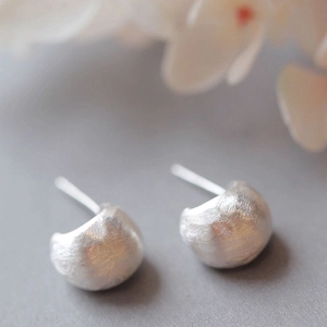 Détail macro de clous d'oreilles en argent S925 avec finition brossée et mate