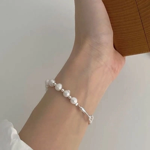 Bracelet élégant en argent s925 avec perles d'eau douce et accents métalliques au poignet